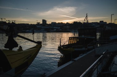 Silhouettes of ancient boats on the Douro River at night in the center of the old city of Porto, Portugal.
