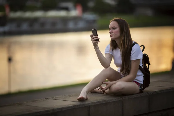 Flicka Med Mobiltelefon Handen Sitter Stadens Strandpromenad — Stockfoto