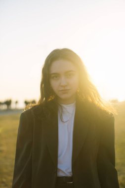 Günbatımının arka planında şık genç bir kadın..