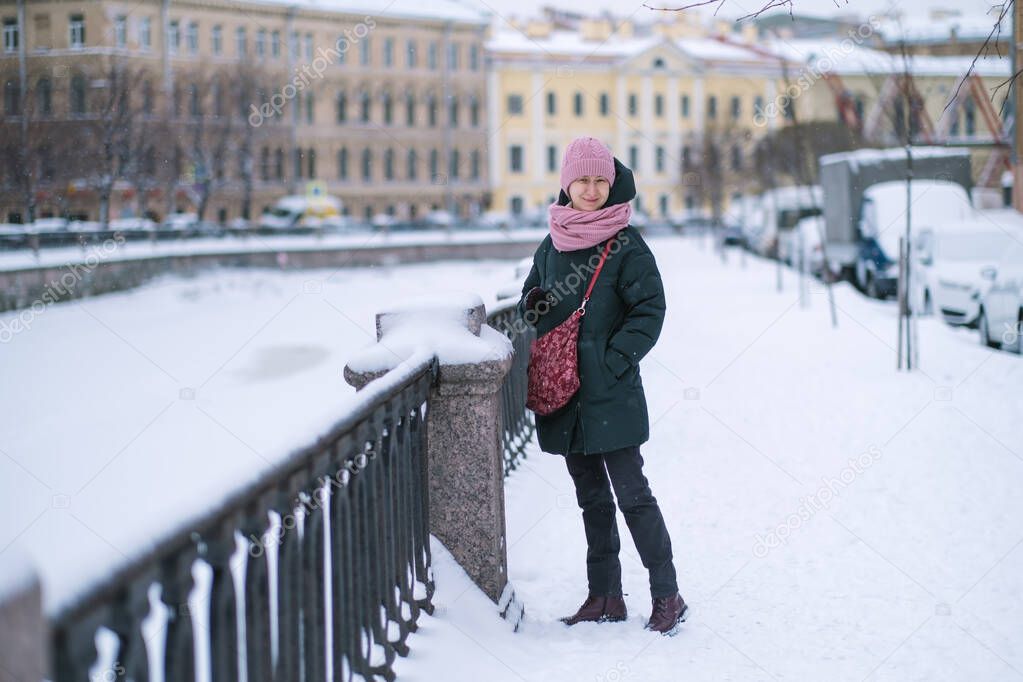 Woman standing near Griboedov Canal in winter, St. Petersburg, Russia. Black and white photo.