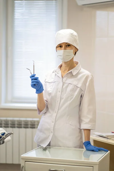 Kvinnlig Tandläkare Hennes Läkarmottagning Bär Ansiktsmask Och Blå Uniformshandskar — Stockfoto