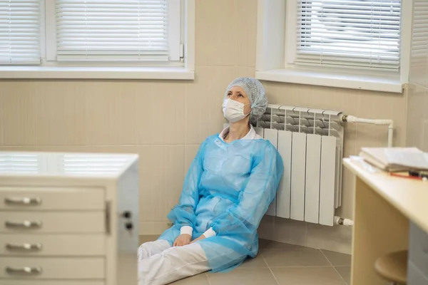 Exausta Uma Médica Senta Cansada Chão Hospital Usando Uma Máscara — Fotografia de Stock