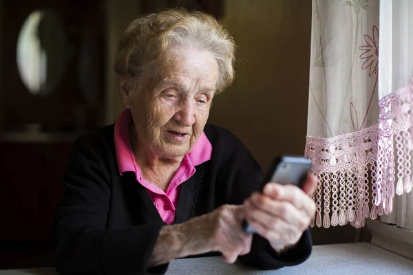 一个老妇人在智能手机上打字 — 图库照片