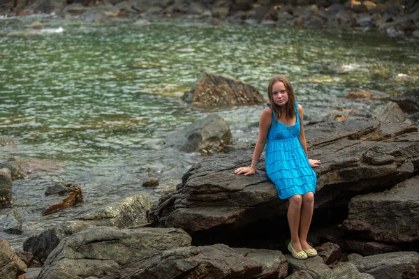 Adolescente Abito Blu Siede Una Spiaggia Rocciosa Sul Mare Foto Stock