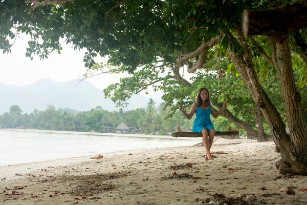 Una Ragazza Siede Altalena Una Spiaggia Tropicale Foto Stock