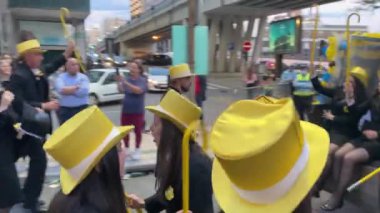 PORTO, PORTUGAL - 3 Mayıs 2022: Cortejo Queima das Fitas sırasında Portekizli üniversite öğrencilerinin yıllık şenliği. Mezunlar bir silindir şapka ve baston takıyorlar. İkisi de fakültenin renginde..