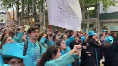 PORTO, PORTUGAL - 3 Mayıs 2022: Cortejo Queima das Fitas sırasında Portekizli üniversite öğrencilerinin yıllık şenliği. Mezunlar bir silindir şapka ve baston takıyorlar. İkisi de fakültenin renginde..