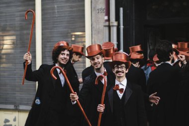 PORTO, PORTUGAL - 3 Mayıs 2022: Cortejo Queima das Fitas sırasında Portekizli üniversite öğrencilerinin yıllık şenliği. Mezunlar bir silindir şapka ve baston takıyorlar. İkisi de fakültenin renginde..