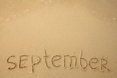 Eylül - yumuşak kumsalda el yazısı yumuşak bir dalgayla.