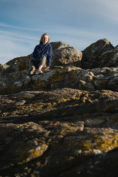 Bir Kadın Okyanus Kıyısındaki Kayalarda Oturuyor — Stok fotoğraf