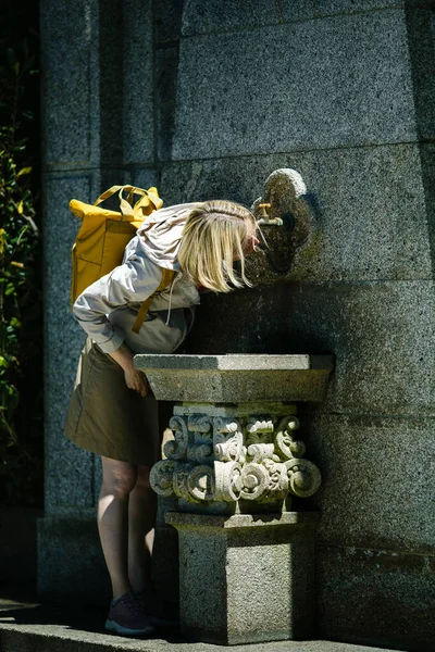 Eine Touristin Trinkt Aus Einem Mittelalterlichen Trinkbrunnen Stockbild