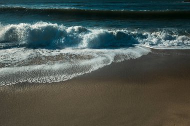 The foamy surf during sunset on the Atlantic coast.