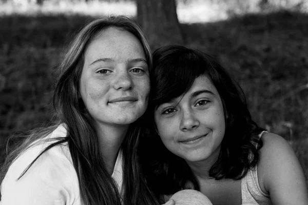 Two sisters outdoor portrait. Black and white photo.