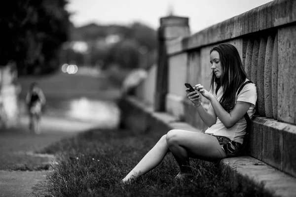 Girl Taiping Text Her Cell Phone Outdoors Black White Photo lizenzfreie Stockfotos