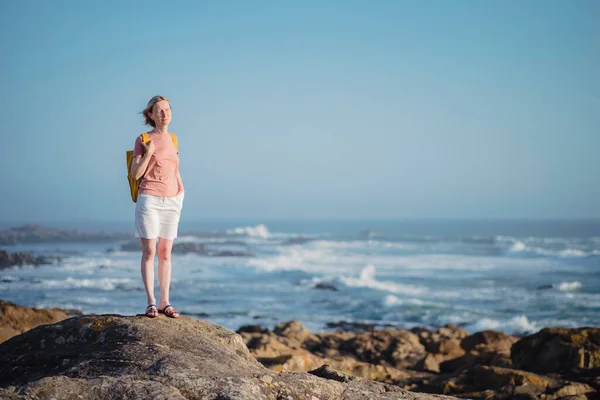 Een Vrouw Met Een Rugzak Staat Rotsen Bij Zee — Stockfoto