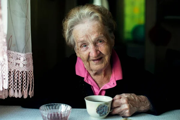 Portrait of an elderly grandmother with a cup of tea. 