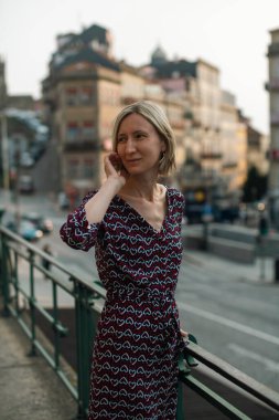 A middle-aged woman on the street of an old European city.