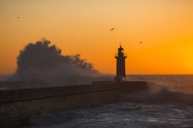Atlantik Okyanusu 'ndaki deniz feneri manzarası inanılmaz günbatımında Porto, Portekiz.