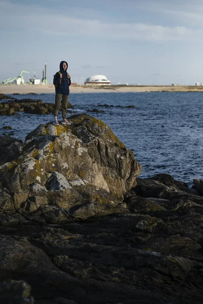 一位女游客站在海滨悬崖上的港口附近 — 图库照片