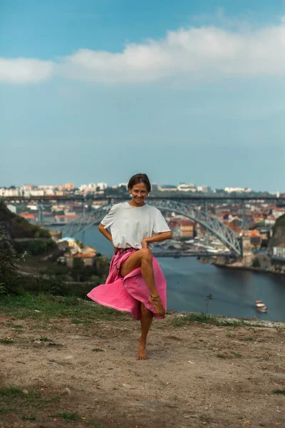 ポルトガルのポルトの街の川のほとりで踊る女性 — ストック写真