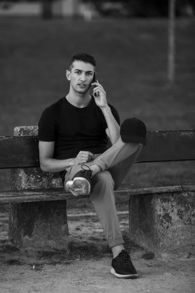 Beau Jeune Homme Assis Sur Banc Parlant Sur Son Téléphone — Photo