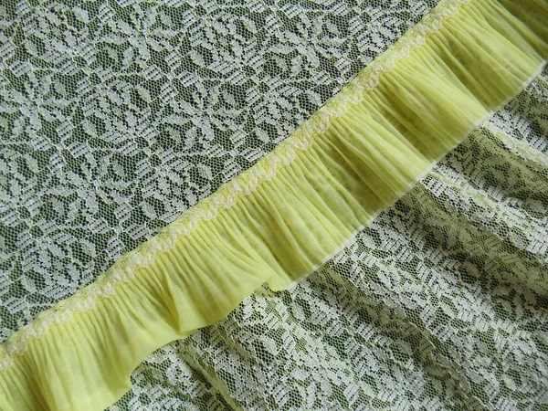 Närbild. en detalj av en citrongul spets underkläder med en sömlös abstrakt mönster. — Stockfoto