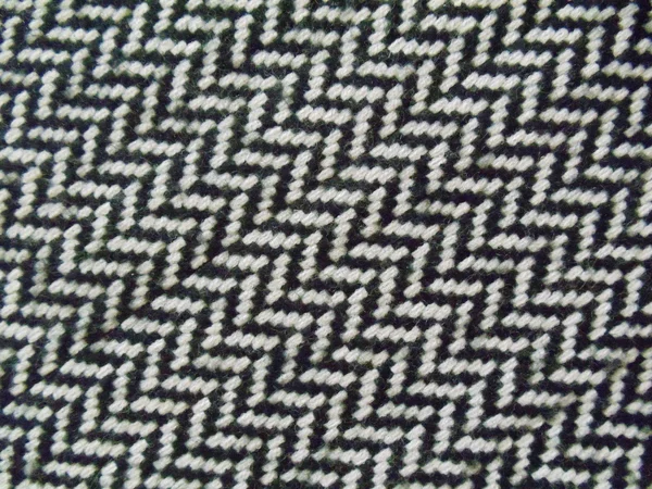 Background. Natural woolen fabric with a seamless black and white geometrical pattern. — Stock Photo, Image