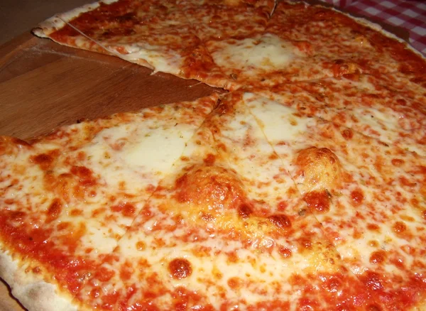 新鲜的比萨用一块刚切出特别的木托盘上的"玛格丽塔". — 图库照片