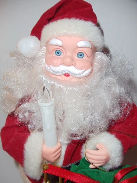 Um velho brinquedo Papai Noel com uma vela na mão .. — Fotografia de Stock