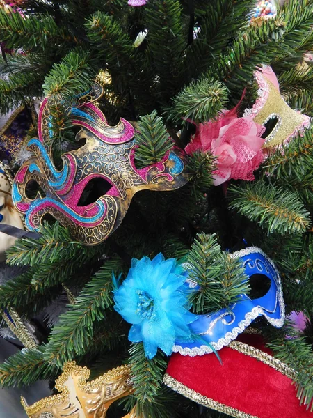 Karnevalové masky na větvích vánočního stromu. vánoční hračky pozadí. — Stock fotografie