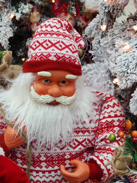 Ein Spielzeug-Weihnachtsmann mit einem Sack mit Geschenken neben dem Weihnachtsbaum. — Stockfoto
