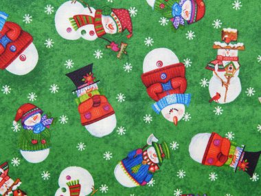 Background. Texture. Fabric with a seamless pattern with various snowmen on a green background. clipart