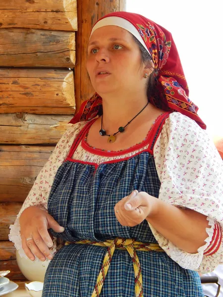 Folk crafts. A woman-potter in a national dress.The Fourth International Historical Festival "Times and Epochs 1914-2014", Kolomenskoye, Moscow. 8th of June, 2014. — Stock Photo, Image