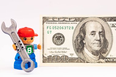 Tasarım amaçlı 100 dolarlık banknotu olan küçük bir adam heykeli.