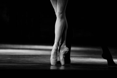 Sahnede yapayalnız dans eden balerinin yakın çekimi. Balerin bacakları yakın plan