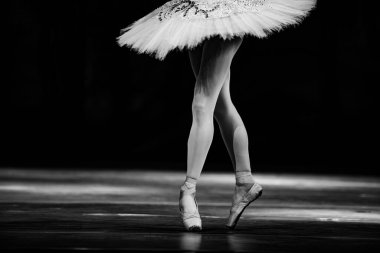 Sahnede yapayalnız dans eden balerinin yakın çekimi. Balerin bacakları yakın plan