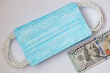Cerrahi maskeler ve 100 dolarlık banknot.