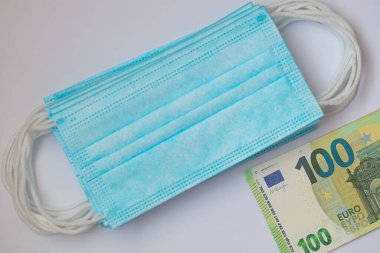 Cerrahi maskeler ve 100 euro banknot.
