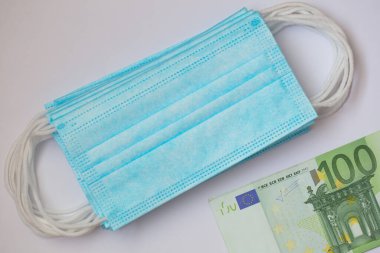 Cerrahi maskeler ve 100 euro banknot.