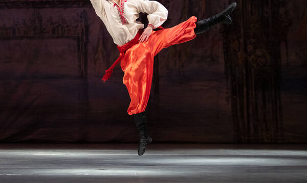 Closeup of classical ballet male dancer dancing hopak - ukrainian folk dance