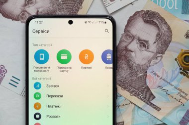 Kyiv, Ukrayna - 1 Aralık 2021: Mobil bankacılık Privat24 uygulamalı akıllı telefon ekranı 1000 Ukrayna Hrivnia banknotları