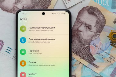 Kyiv, Ukrayna - 1 Aralık 2021: Mobil bankacılık Privat24 uygulamalı akıllı telefon ekranı 1000 Ukrayna Hrivnia banknotları