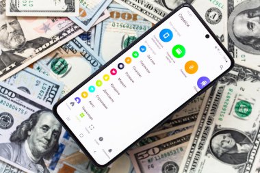 Kyiv, Ukrayna - 1 Aralık 2021: Mobil bankacılık Privat24 uygulamalı akıllı telefon ekranı ABD dolar banknotları geçmişi