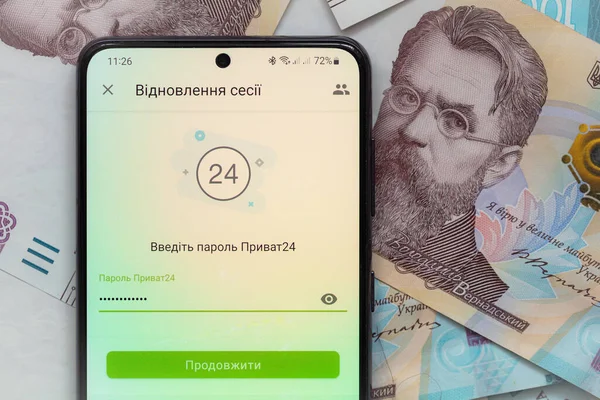 Kyiv, Ukrayna - 1 Aralık 2021: Mobil bankacılık Privat24 uygulamalı akıllı telefon ekranı 1000 Ukrayna Hrivnia banknotları