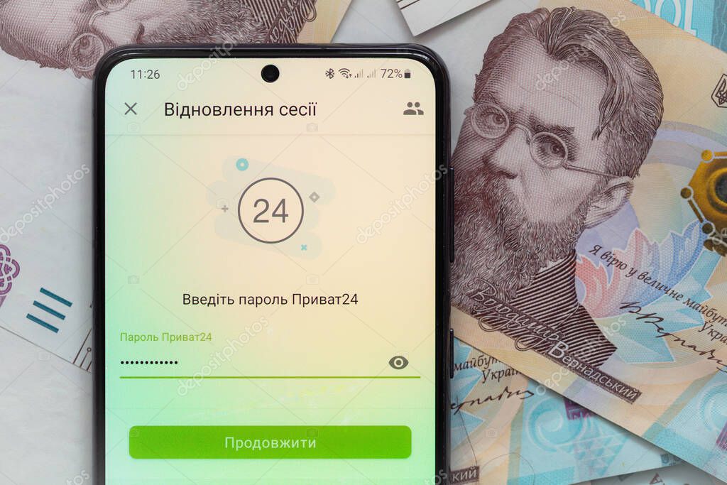 Kyiv, Ukraine - December 1, 2021: smartphone screen with mobile banking Privat24 application on 1000 Ukrainian hryvnia banknotes background