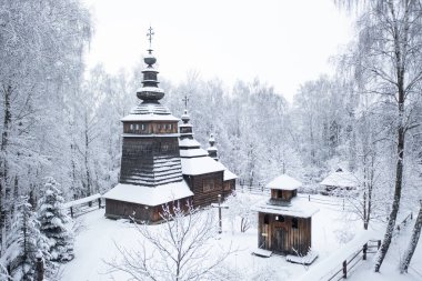 Lviv, Ukrayna - 8 Aralık 2021: Lviv 'deki Klymentii Sheptytskyi Halk Mimarisi ve Kırsal Yaşam Müzesi (Shevchenkivskyi Hai)' deki antik köy ahşap kilisesi. Kışın Skansen