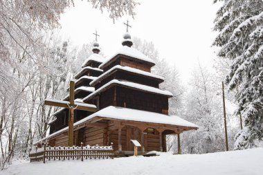 Lviv, Ukrayna - 8 Aralık 2021: Lviv 'deki Klymentii Sheptytskyi Halk Mimarisi ve Kırsal Yaşam Müzesi (Shevchenkivskyi Hai)' deki antik köy ahşap kilisesi. Kışın Skansen