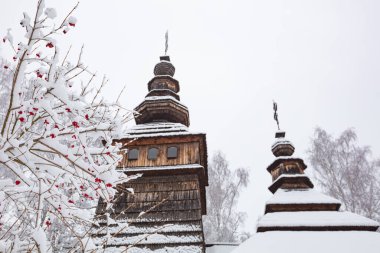 Lviv, Ukrayna - 8 Aralık 2021: Lviv 'deki Klymentii Sheptytskyi Halk Mimarisi ve Kırsal Yaşam Müzesi (Shevchenkivskyi Hai)' deki antik köy ahşap kilisesi. Kışın Skansen