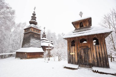 Lviv, Ukrayna - 8 Aralık 2021: Lviv 'deki Klymentii Sheptytskyi Halk Mimarisi ve Kırsal Yaşam Müzesi (Shevchenkivskyi Hai)' deki antik köy ahşap kilisesi. Kışın Skansen