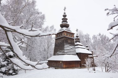 Lviv, Ukrayna - 8 Aralık 2021: Lviv 'deki Klymentii Sheptytskyi Halk Mimarisi ve Kırsal Yaşam Müzesi (Shevchenkivskyi Hai)' deki antik köy ahşap kilisesi. Kışın Skansen
